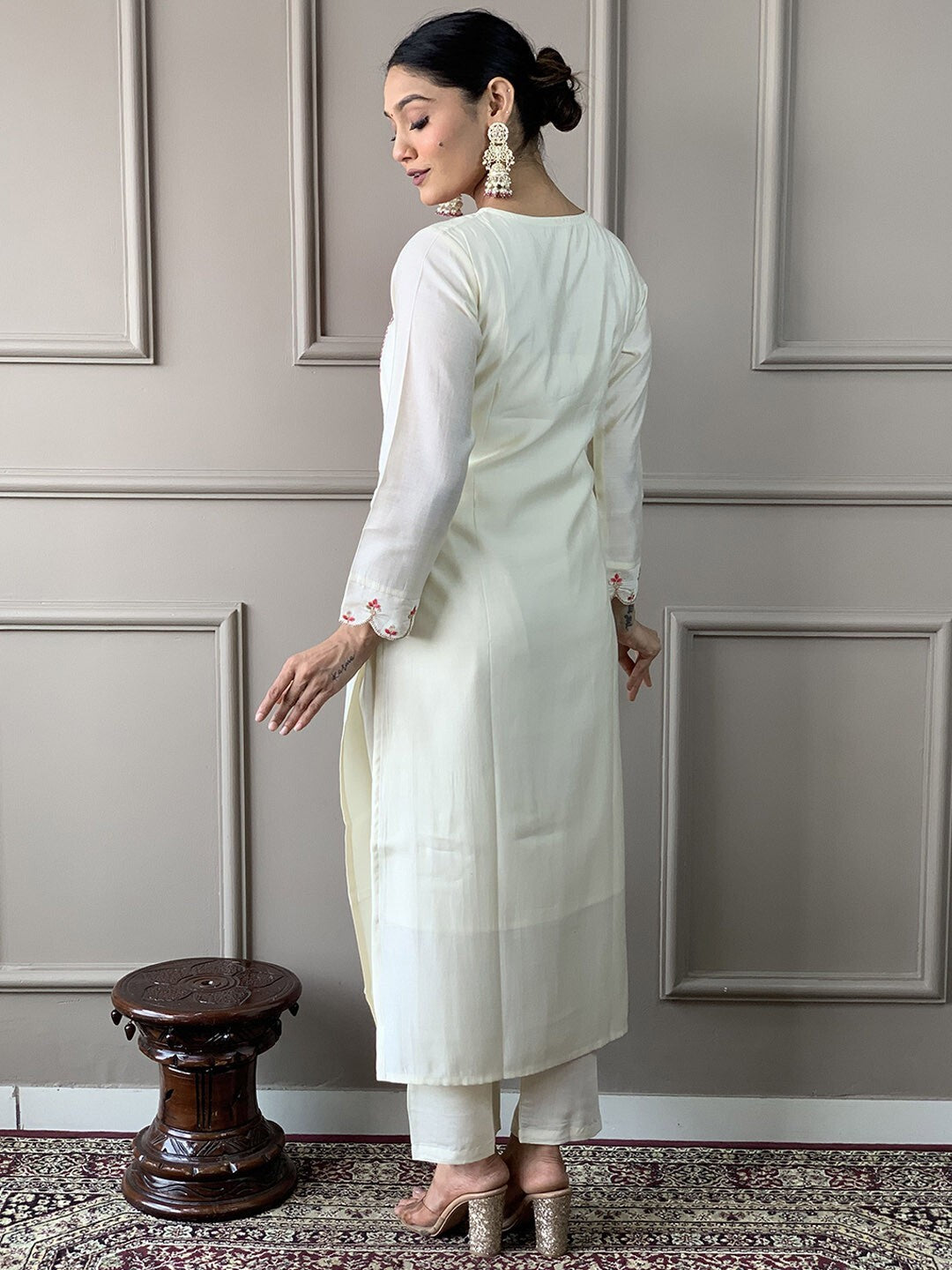 A white straight-cut kurta with pink floral embroidery on the Kurta and Pant set